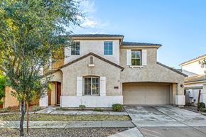 Gilbert apartment for rent - a beige house with a garage door and a tree