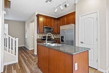 Gilbert apartment for rent - A kitchen with wooden cabinets and a granite countertop.