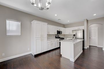 Las Vegas apartment for rent - A kitchen with white cabinets and a wooden floor.