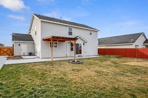 Nampa apartment for rent - a backyard with a white house and a yard with a wooden fence
