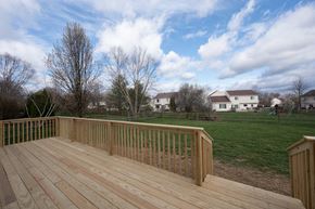 Batavia apartment for rent - A wooden deck overlooks a grassy area with houses in the distance.
