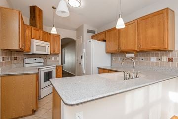 Mesa apartment for rent - A kitchen with wooden cabinets and a white countertop.