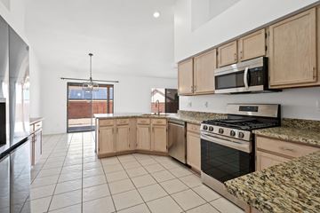 Tucson apartment for rent - A kitchen with a stove top oven and microwave.