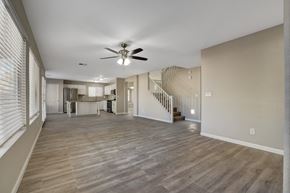 Las Vegas apartment for rent - A spacious living room with a staircase and a ceiling fan.