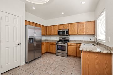 Sahuarita apartment for rent - A kitchen with wooden cabinets and a stainless steel refrigerator.