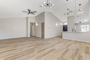 Henderson apartment for rent - A spacious room with wooden flooring and a ceiling fan.