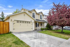 Nampa apartment for rent - a yellow house with a white garage door on a driveway