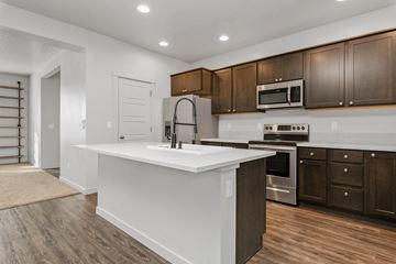 Meridian apartment for rent - A modern kitchen with dark brown cabinets and white countertops.