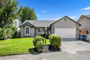 Boise apartment for rent - A house with a grey garage door and a white window.