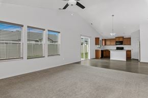 Nampa apartment for rent - A spacious living room with a ceiling fan and large windows.