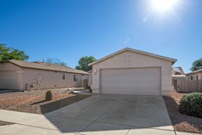 Tucson apartment for rent - a beige house with a driveway and a garage door