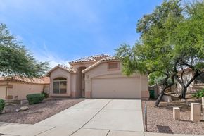 Oro Valley apartment for rent - a beige house with a driveway and trees
