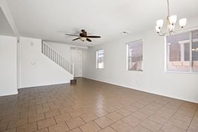 Tucson apartment for rent - an empty living room with a ceiling fan and a staircase