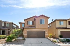 Tucson apartment for rent - a beige house with a driveway and a garage door