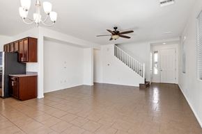Tucson apartment for rent - an empty living room with a ceiling fan and a staircase