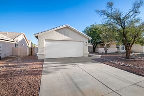 Tucson apartment for rent - A house with a garage is surrounded by a gravel driveway.
