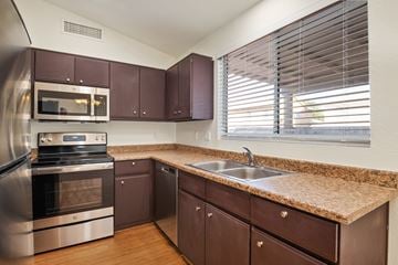 Tucson apartment for rent - A kitchen with brown cabinets and a granite countertop.