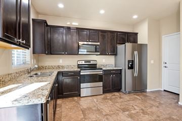 Vail apartment for rent - A kitchen with brown cabinets and a refrigerator.