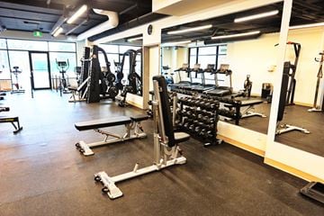 Moncton apartment for rent - A gym with a variety of equipment including weights and treadmills.