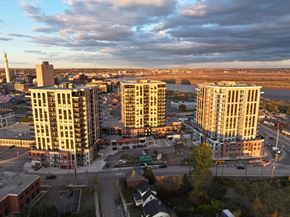 Moncton apartment for rent - A cityscape with buildings and a cloudy sky.