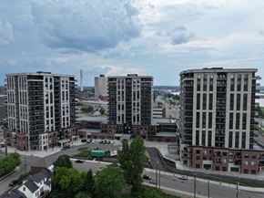 Moncton apartment for rent - A cityscape with three tall buildings in the foreground and a cloudy sky above.