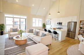 Moncton apartment for rent - A modern living room with a kitchen in the background.