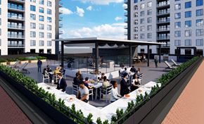 Moncton apartment for rent - A group of people are sitting at tables under a large canopy on a rooftop.