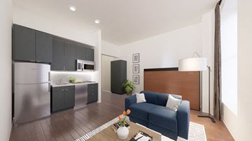 Baltimore apartment for rent - a living room with a blue couch and a kitchen with stainless steel appliances