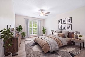 Charlotte apartment for rent - A bedroom with a large bed, a ceiling fan, and a rug on the floor.