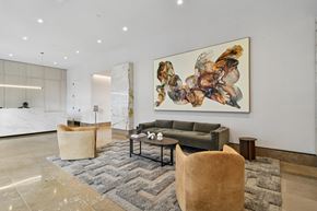 New York apartment for rent - A large abstract painting hangs above a grey couch in a spacious room.