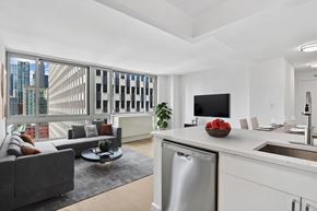 New York apartment for rent - A modern kitchen with a dining table and chairs, a couch, a TV, and a large window with a view of the city.