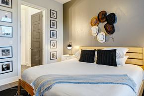Nashville apartment for rent - a bedroom with a bed and various hats on the wall