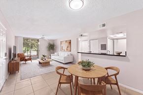 Coral Springs apartment for rent - A living room with a white couch, a wooden table, and chairs.