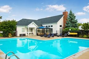 Columbus apartment for rent - a swimming pool with chairs in front of a house