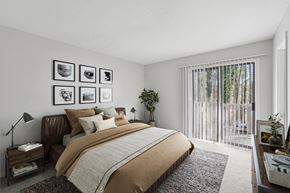 Raleigh apartment for rent - A bedroom with a large bed and a window with blinds.