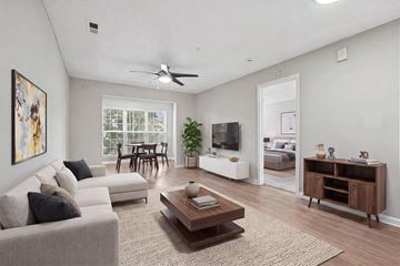 Charlotte apartment for rent - A living room with a grey couch, a brown coffee table, and a painting on the wall.