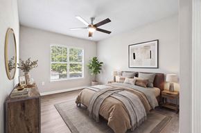 Charlotte apartment for rent - A bedroom with a large bed and a ceiling fan.
