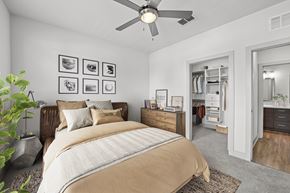 Kissimmee apartment for rent - A bedroom with a large bed and a ceiling fan.