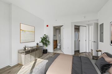 Mclean apartment for rent - A living room with a grey sofa and a wooden cabinet.