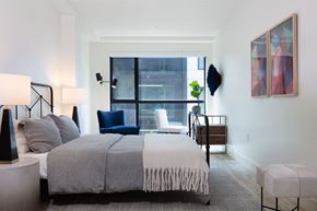 Oakland apartment for rent - A bedroom with a large bed and a chair.