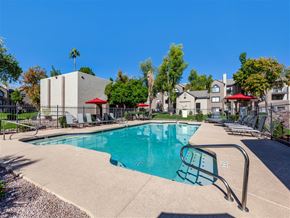 Mesa apartment for rent - a swimming pool with a fence and a building in the background