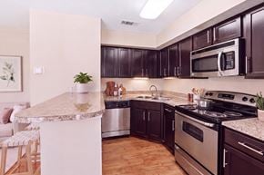 Austin apartment for rent - A kitchen with dark brown cabinets and stainless steel appliances.