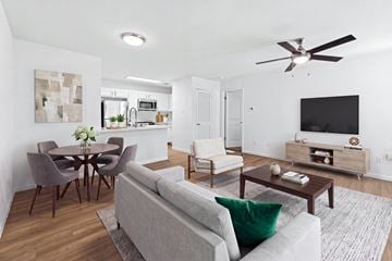 Austin apartment for rent - A modern living room with a grey couch and a wooden dining table.