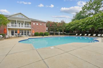 Charlotte apartment for rent - A large swimming pool in front of a building with a red brick exterior.