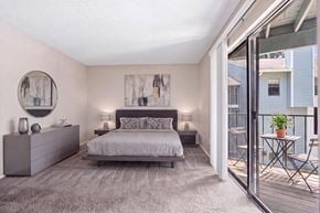 Charlotte apartment for rent - A bedroom with a large bed and a balcony.