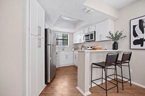 Charlotte apartment for rent - A kitchen with white cabinets and a black fridge.