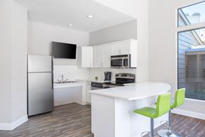 Charlotte apartment for rent - A modern kitchen with a white island and green bar stools.
