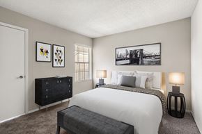 Charlotte apartment for rent - A bedroom with a large bed and a black bench.