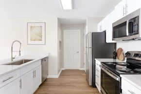 Charlotte apartment for rent - a kitchen with white cabinets and stainless steel appliances and a black refrigerator