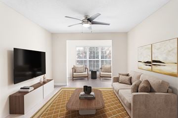 Charlotte apartment for rent - A living room with a brown couch, a coffee table, a flat screen TV, and a painting on the wall.